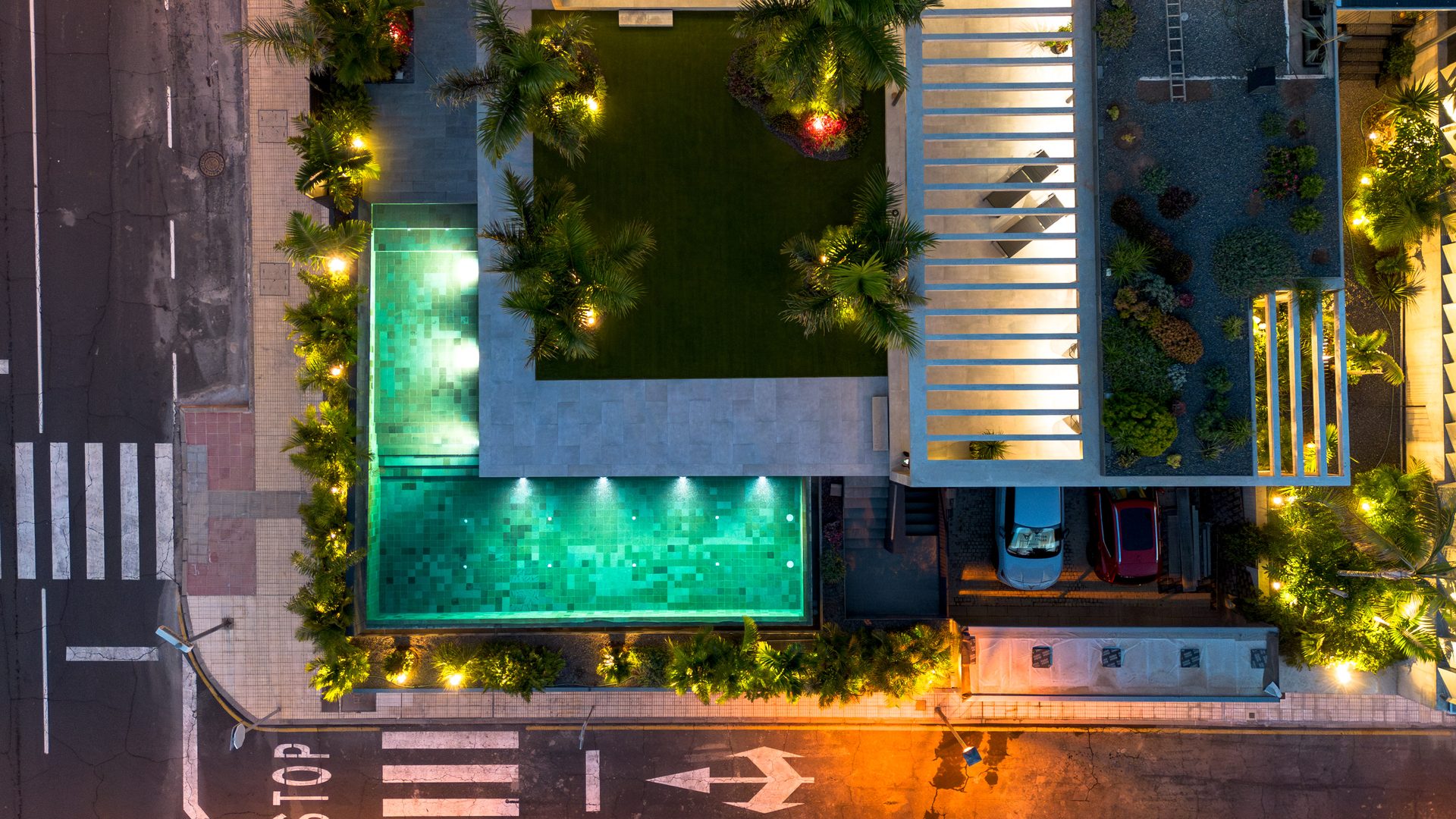 Vista cenital de Villa Bali de noche: jardín central, piscina iluminada y cubiertas, Playa Paraíso