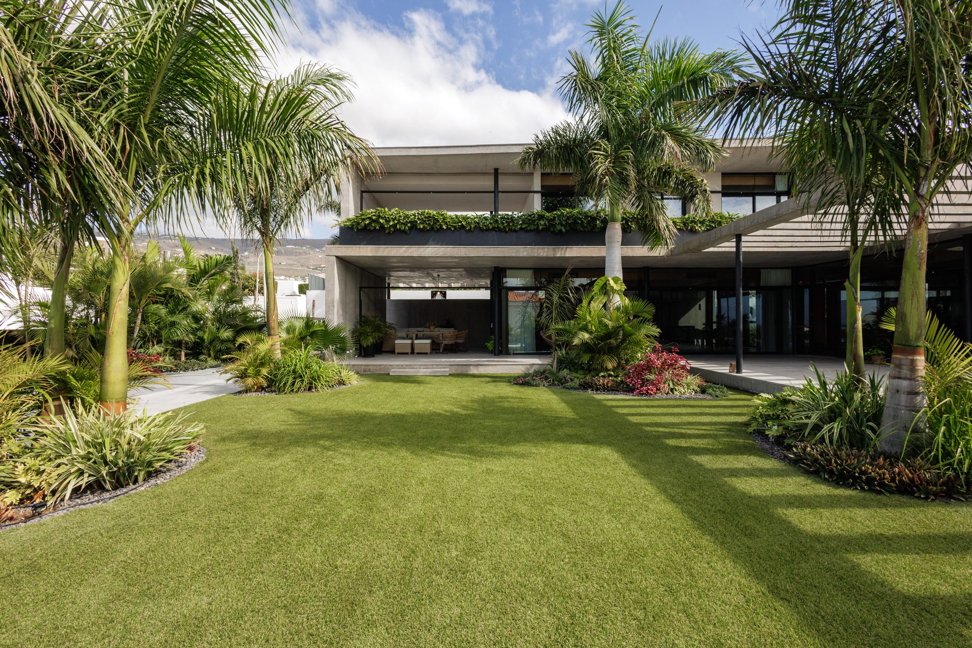 Jardín de Villa Bali con palmeras y la fachada de hormigón y vidrio, Costa Adeje
